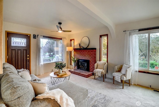 living room with ceiling fan, a fireplace, and carpet