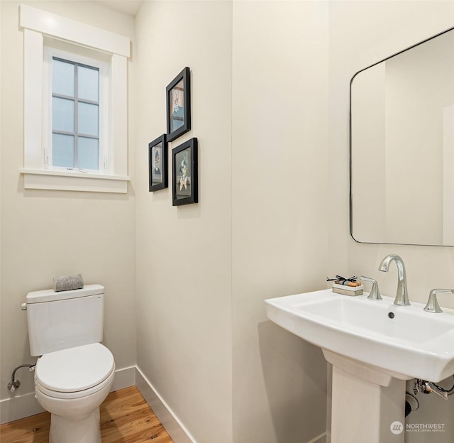 bathroom featuring hardwood / wood-style flooring, toilet, and sink