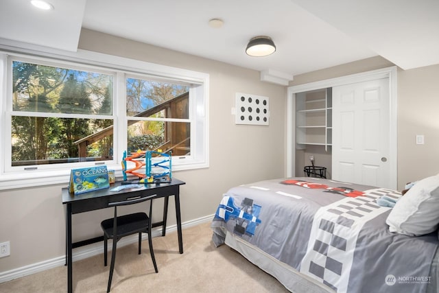 bedroom featuring light colored carpet and a closet