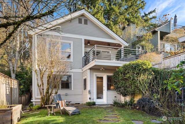 back of house with a balcony and a lawn