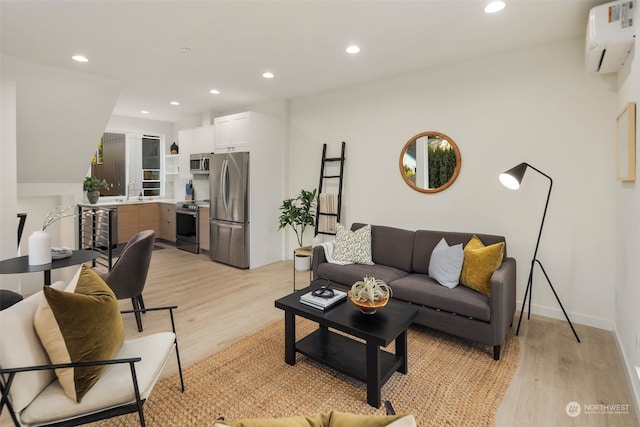 living room with sink, a wall mounted AC, and light wood-type flooring