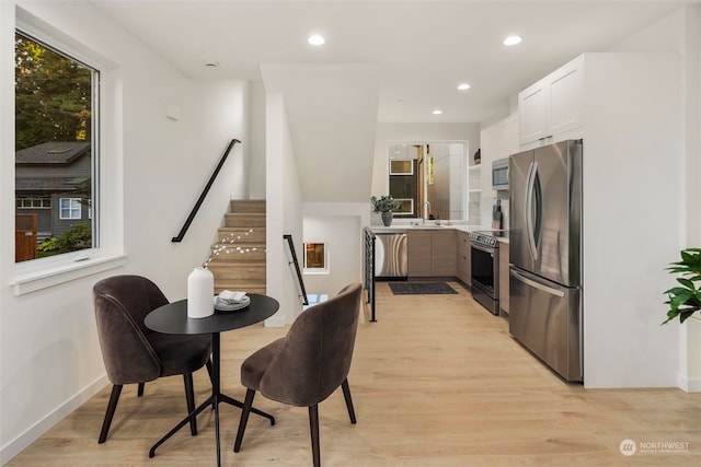 dining area featuring sink and light hardwood / wood-style floors