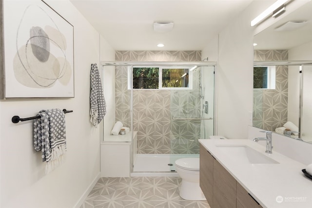 bathroom featuring vanity, toilet, and a shower with shower door