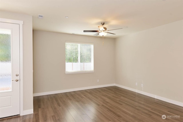 spare room with dark wood-type flooring and ceiling fan