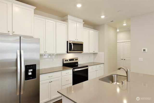 kitchen with white cabinetry, sink, decorative backsplash, and appliances with stainless steel finishes