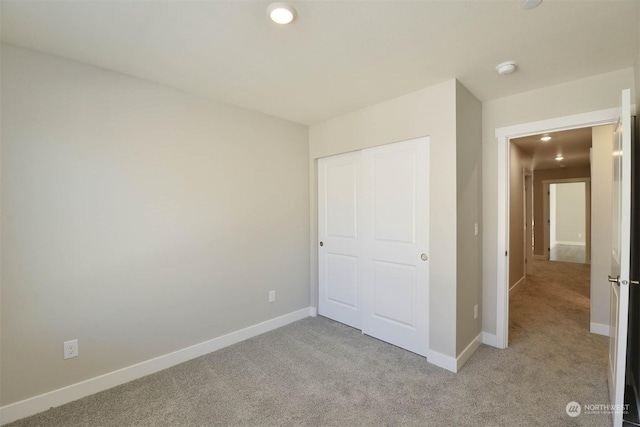 unfurnished bedroom with a closet and light carpet