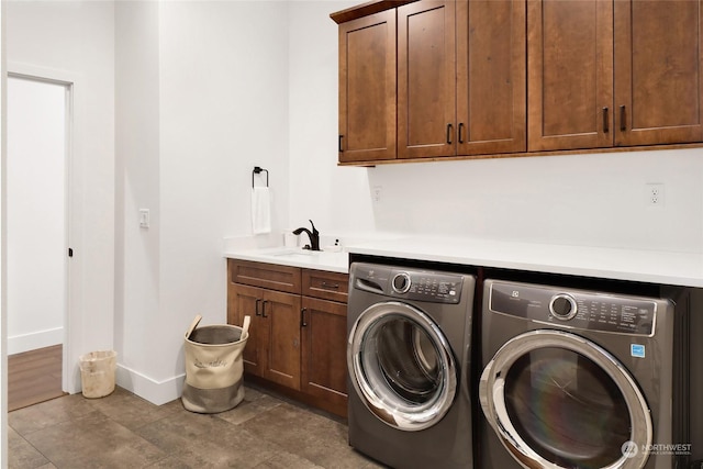 laundry area with cabinets, sink, and washer and clothes dryer