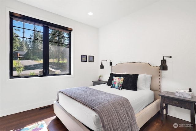 bedroom with dark hardwood / wood-style floors