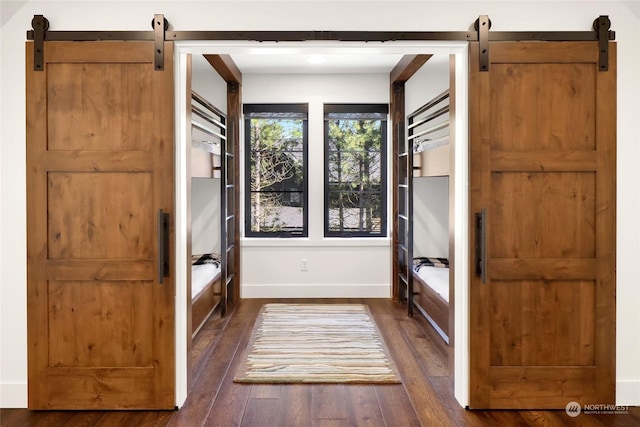 interior space featuring a barn door and dark wood-type flooring