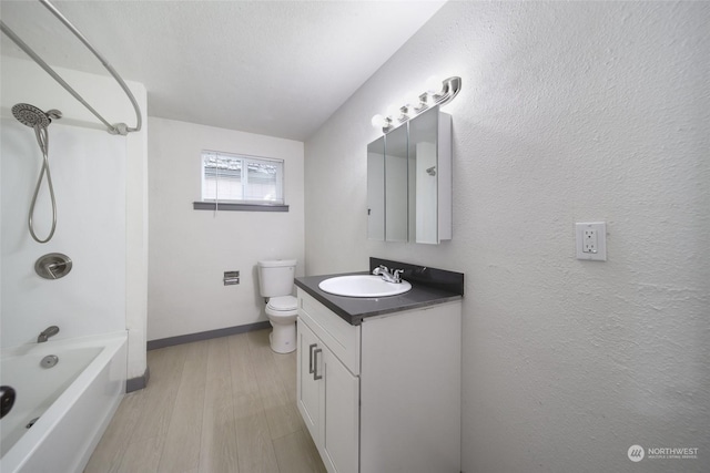 full bathroom featuring vanity, hardwood / wood-style floors, tub / shower combination, and toilet