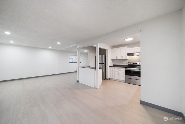 kitchen featuring stainless steel appliances, white cabinetry, a textured ceiling, and light wood-type flooring