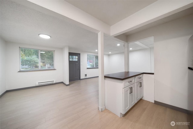 kitchen with a baseboard radiator, light hardwood / wood-style floors, and white cabinets