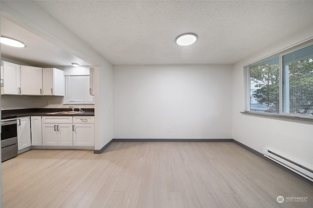 kitchen with white cabinetry, light hardwood / wood-style floors, stainless steel range with electric stovetop, and baseboard heating