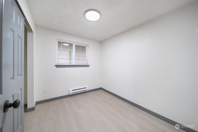 unfurnished bedroom featuring a baseboard heating unit, light hardwood / wood-style flooring, a closet, and a textured ceiling