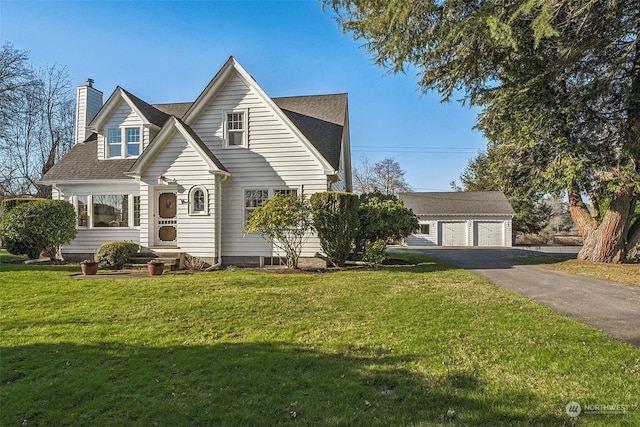 view of front facade featuring a garage, an outdoor structure, and a front lawn