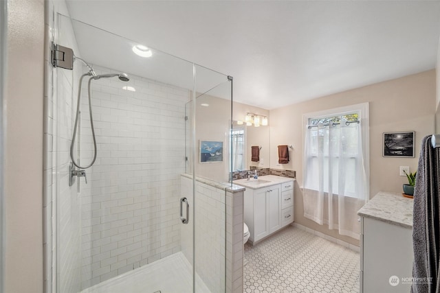 bathroom with vanity, a shower with shower door, and toilet