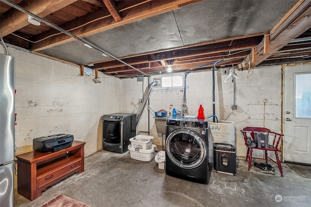 basement with stainless steel fridge and independent washer and dryer