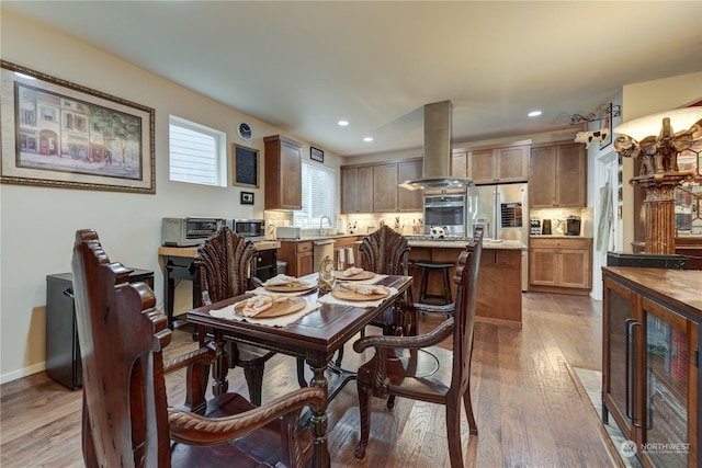 dining space with sink, beverage cooler, and light hardwood / wood-style floors