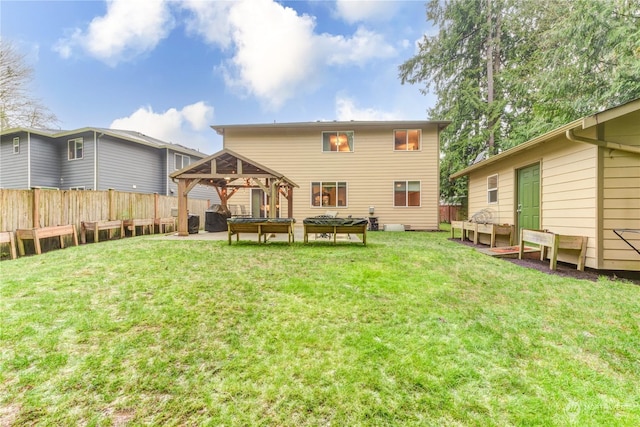 rear view of house with a gazebo and a yard