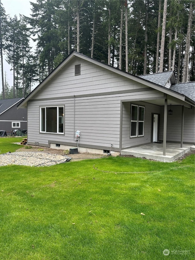 back of house with a patio area and a lawn