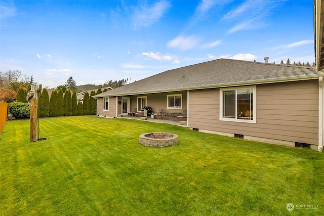 rear view of house featuring a yard, a patio area, and a fire pit