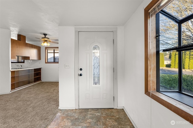 carpeted foyer with ceiling fan