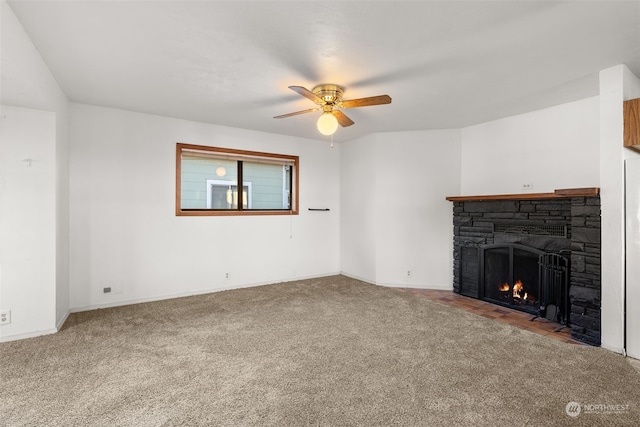 unfurnished living room with ceiling fan, a stone fireplace, and carpet floors