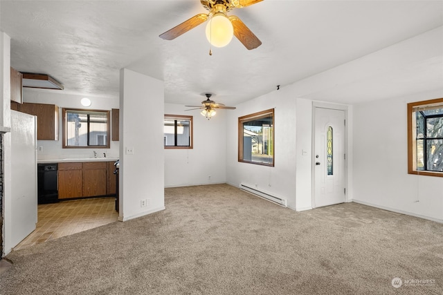 unfurnished living room featuring a wealth of natural light, light carpet, and a baseboard heating unit