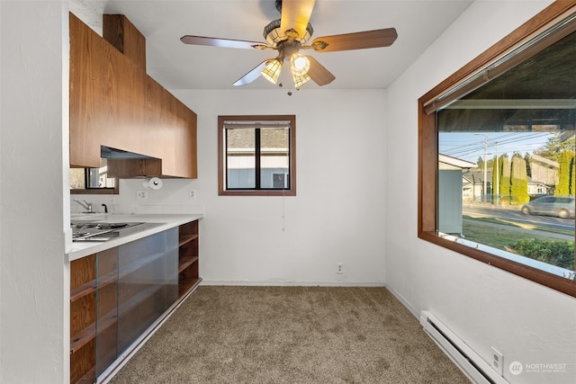 kitchen with stainless steel gas stovetop, a baseboard heating unit, light carpet, and ceiling fan