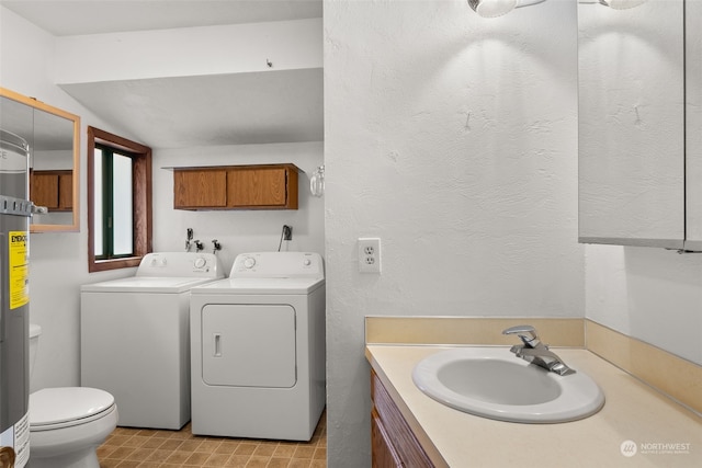 bathroom featuring vanity, washing machine and dryer, and toilet