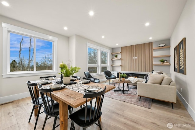 dining area with light wood finished floors, recessed lighting, visible vents, and baseboards