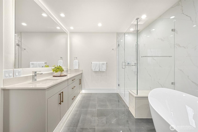 full bath with a marble finish shower, double vanity, recessed lighting, a soaking tub, and a sink