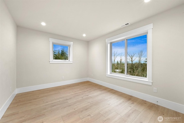 unfurnished room featuring recessed lighting, visible vents, light wood-style flooring, and baseboards