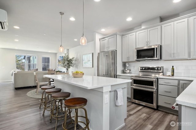 kitchen with pendant lighting, stainless steel appliances, a center island, and tasteful backsplash