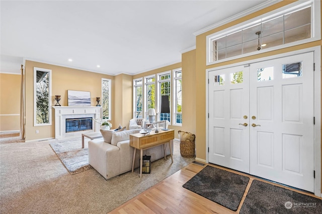 foyer with ornamental molding and hardwood / wood-style floors