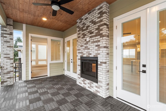 view of patio with french doors, ceiling fan, and an outdoor brick fireplace