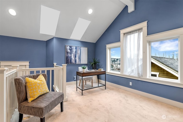 carpeted office featuring vaulted ceiling with skylight