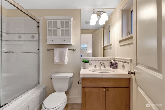 bathroom featuring vanity, backsplash, an inviting chandelier, and toilet