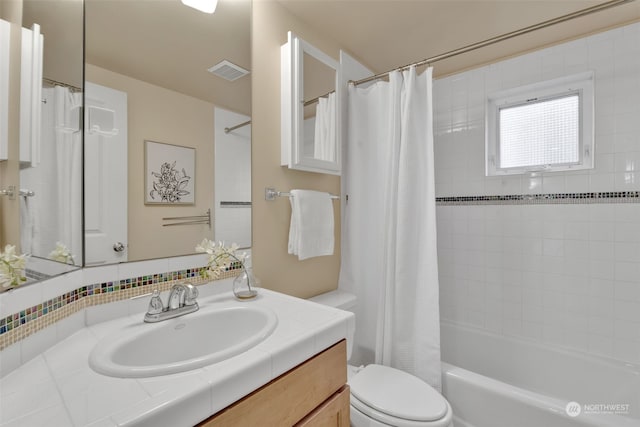 full bathroom featuring shower / tub combo with curtain, vanity, and toilet