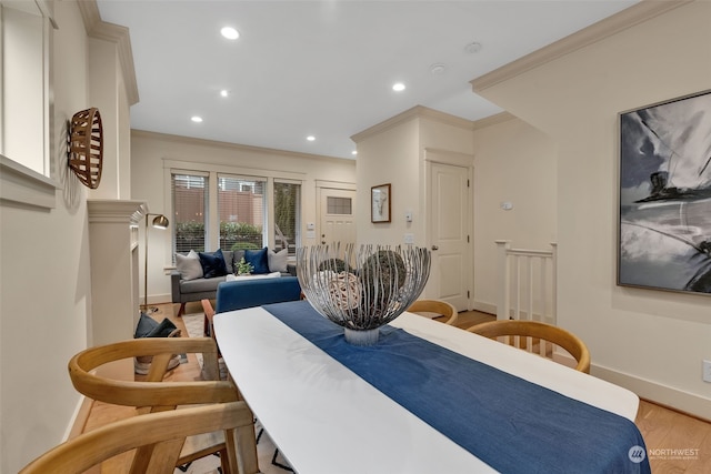 dining area with crown molding and light hardwood / wood-style flooring