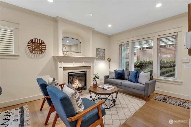 living room featuring crown molding, a fireplace, and light hardwood / wood-style flooring