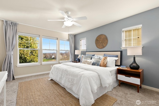 bedroom with light colored carpet, baseboards, and ceiling fan