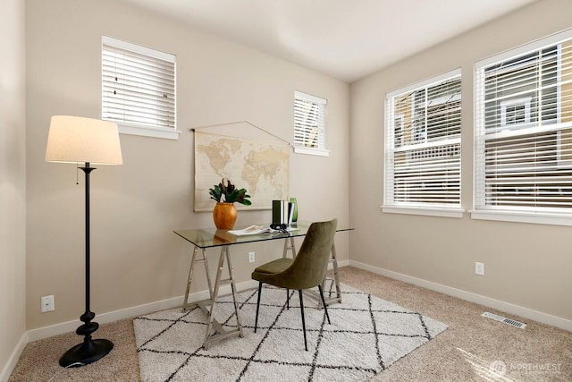 carpeted office with baseboards and visible vents