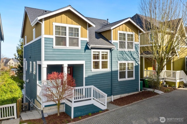 back of property featuring covered porch, board and batten siding, and a shingled roof