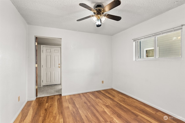 spare room featuring ceiling fan, hardwood / wood-style floors, and a textured ceiling