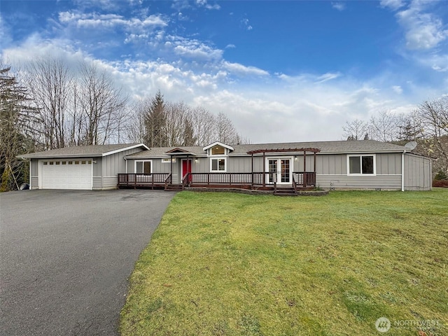 view of front of property with a deck, aphalt driveway, board and batten siding, and a front yard