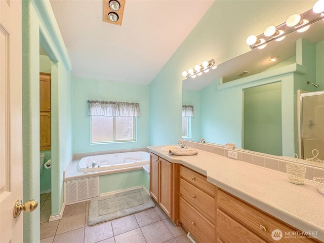 full bathroom featuring a garden tub, lofted ceiling, visible vents, vanity, and tile patterned floors