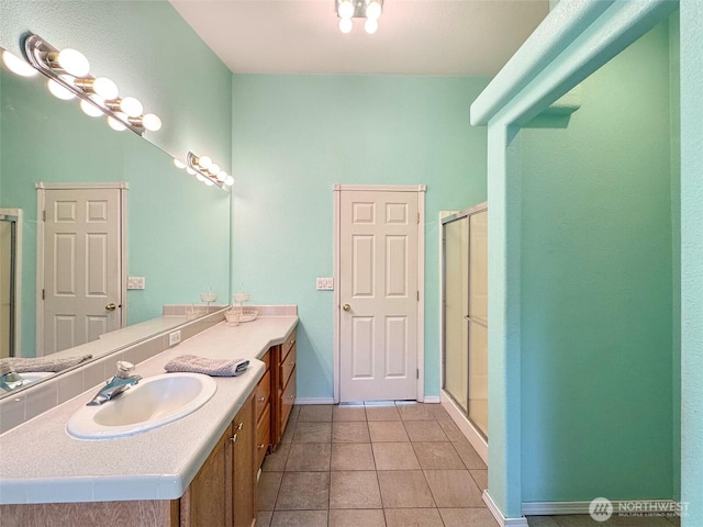 bathroom featuring a shower stall, tile patterned flooring, baseboards, and vanity