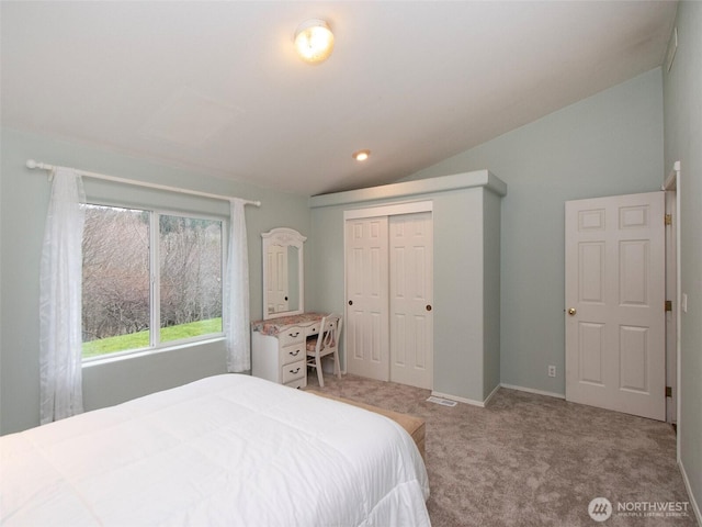 bedroom featuring carpet floors, lofted ceiling, a closet, and baseboards