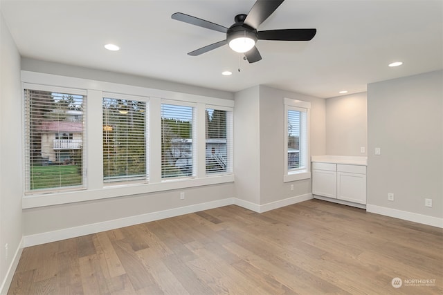 unfurnished room with ceiling fan and light wood-type flooring